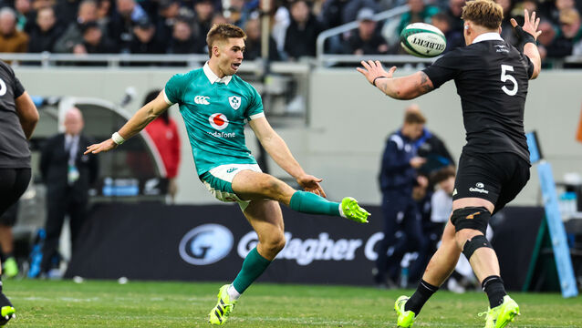 <p>Ireland’s Jack Crowley chips the ball over Fabian Holland of New Zealand. Picture: INPHO/Gary Carr</p>