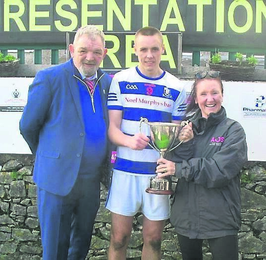 Seandún chairman Mick Buckley and AOS Security managing director Jess O’Sullivan present the trophy to Ballyphehane captain Cian O’Brien. Seandún chairman Mick Buckley and AOS Security managing director Jess O’Sullivan present the trophy to Ballyphehane captain Cian O’Brien.