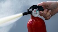 Woman using fire extinguisher, close-up
