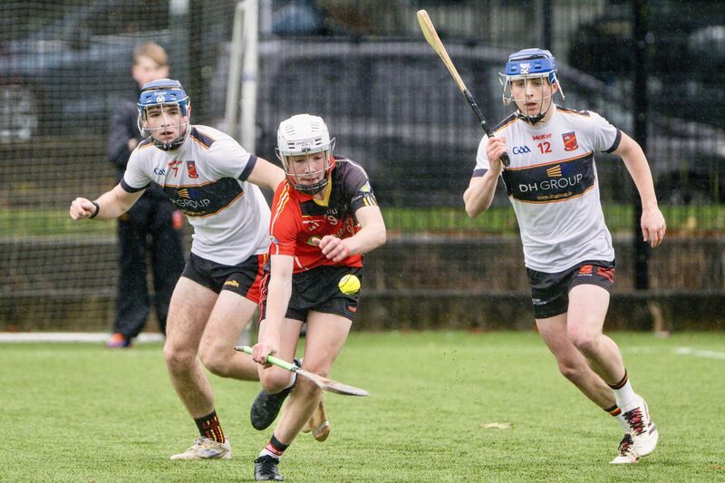 Coachford’s Jack Casey gets away under pressure from Ardscoil Rís’s Shane Waters and Rian Collins. Picture Chani Anderson.