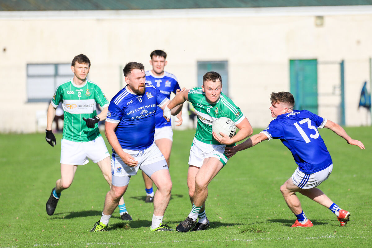 Aghabullogue's Shane Tarrant breaks away from Naomh Abán's Mick Dinneen and Donal Kelly at the Castle Grounds, Macroom. Picture: David Creedon