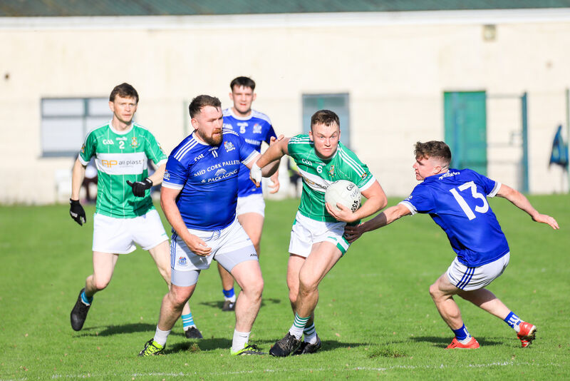Aghabullogue's Shane Tarrant breaks away from Naomh Abán's Mick Dinneen and Donal Kelly at the Castle Grounds, Macroom. Picture: David Creedon