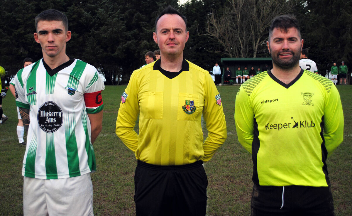 Corkbeg's captain Ray Savage (right), with Waterloo's Jack Homan, accompanied by referee Paul Cavanagh.