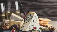 iStock-1364095858.jpg Different arts of cheese with grape on wooden