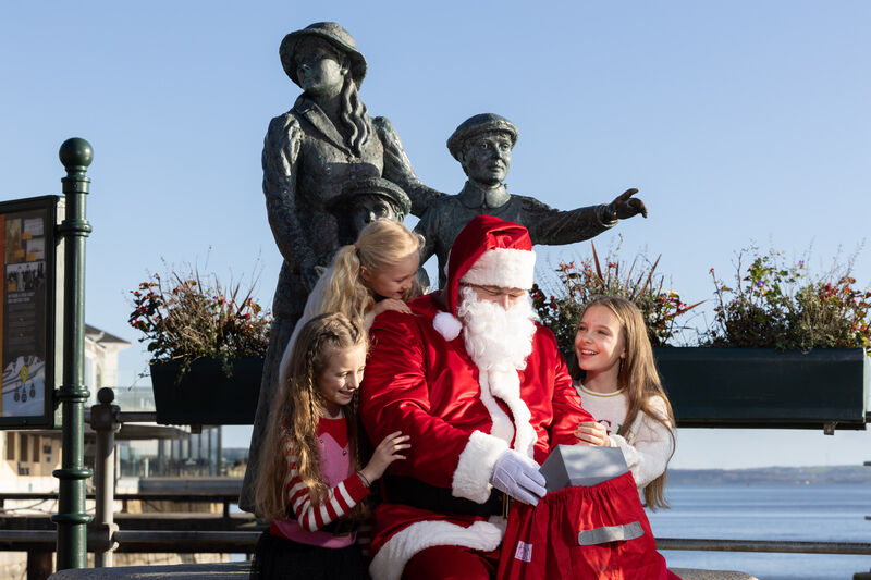 Eve, Simone and Nicole Keating with Santa by the Annie Moore Statue in Cobh at the launch of the Cobh Santa Express, a magical Christmas Experience which is taking place for the first time in the Cobh Heritage Centre. Picture: Darragh Kane