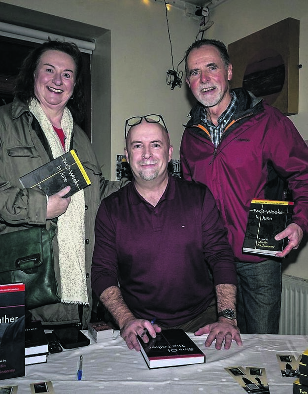 Martin McSweeney signing a copy of Sins Of The Father for Helen Brady and Tim O’Riordan at the launch in Counihan’s Bar, Cork city. 	Picture: Chani Anderson
                        