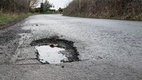 Deep road pothole filled with rainwater.