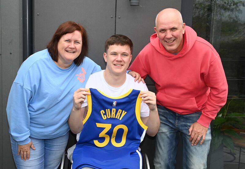 Adam Drummond, Neptune Under 20 coach, Cork, with a signed jersey worn by Steph Curry, NBA basketball superstar, which he was presented with, photographed with his parents Brian and Mar. Adam Drummond, Neptune Under 20 coach, Cork, with a signed jersey worn by Steph Curry, NBA basketball superstar, which he was presented with, photographed with his parents Brian and Mar.