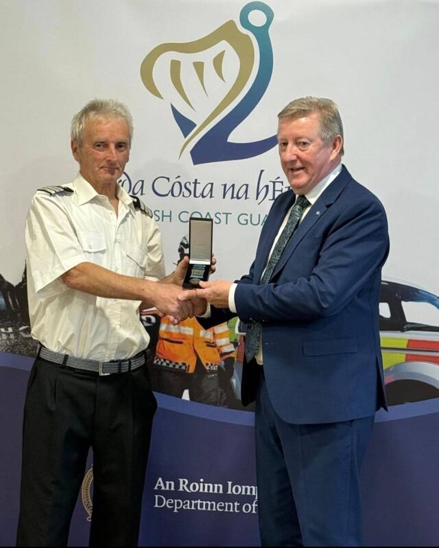 Minister of State Sean Canney presenting John with his medal after 50 years of service..