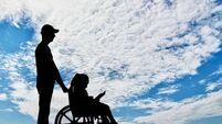 A disabled girl in a wheelchair and her dad on a walk reading a book