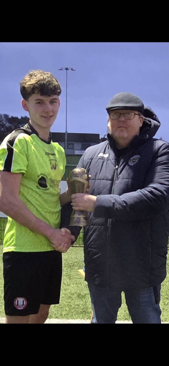 Ger Murphy of the Munster Football Association presents the man of the match award to the Cork keeper Zack Lynch-Healy after the Munster Youth Inter-League Cup final at Carrig Park