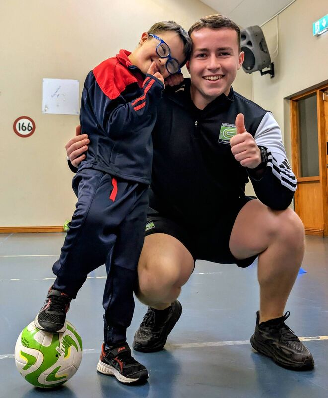 Coerver coach Luke Noonan with one of the children from Our Lady of Good Counsel on their recent visit to the school.
