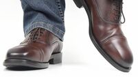 Men's legs in jeans shod in classic brown Oxford shoes