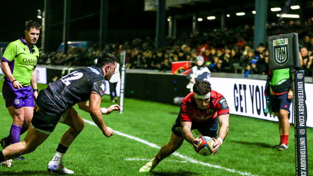 <p>Shane Daly of Munster scores his side's first try despite the attempts of Owen Watkin of Ospreys at Brewery Field. Picture: Gruff Thomas/Sportsfile</p>