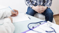 A male patient consults with a doctor about prostate cancer or some other disease.