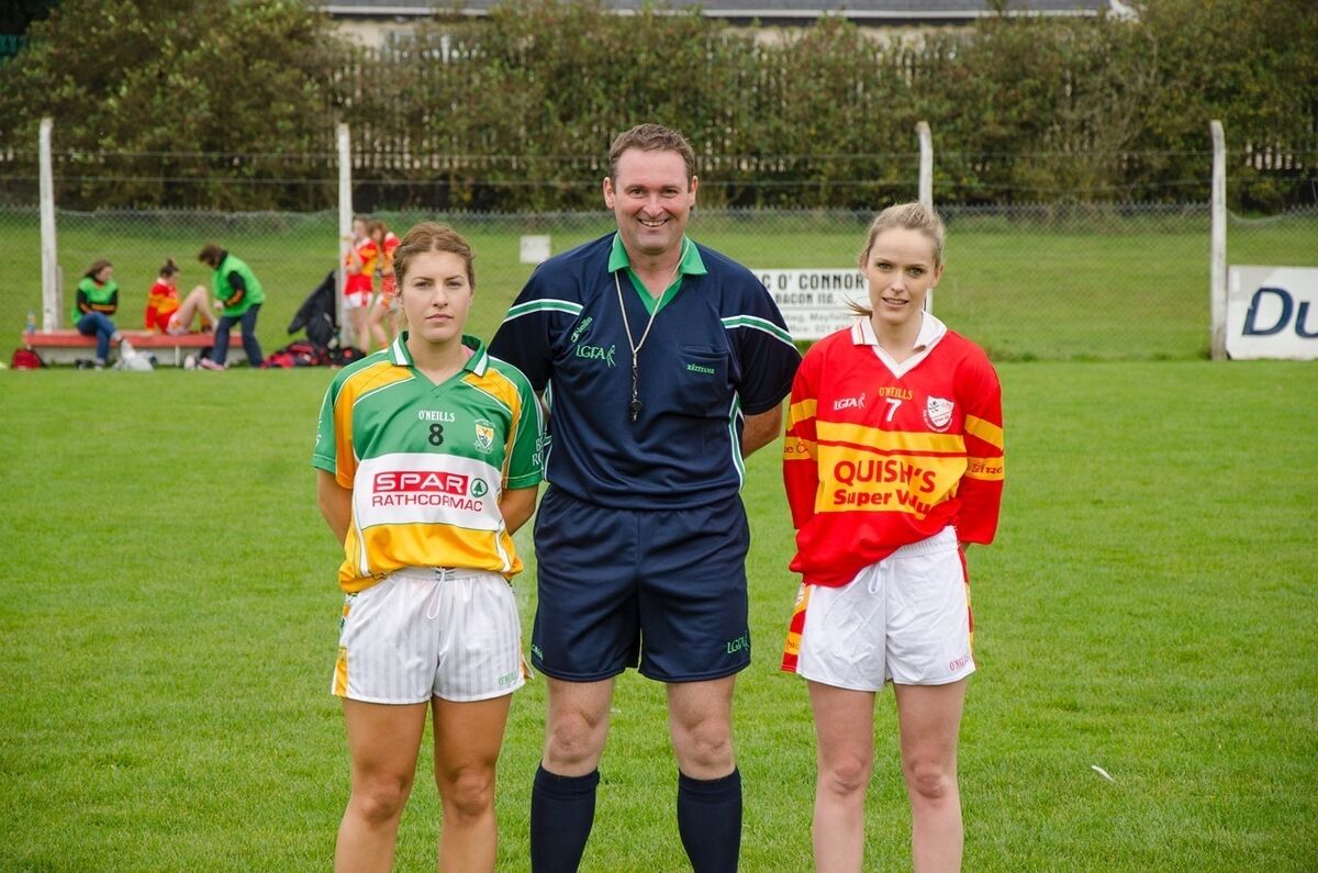 Referee AJ Cronin with Bride Rovers captain Eleanor Ahern and Éire Óg captain Aoife Rodgers in 2015 prior to the Senior B county final in Mayfield. Referee AJ Cronin with Bride Rovers captain Eleanor Ahern and Éire Óg captain Aoife Rodgers in 2015 prior to the Senior B county final in Mayfield.