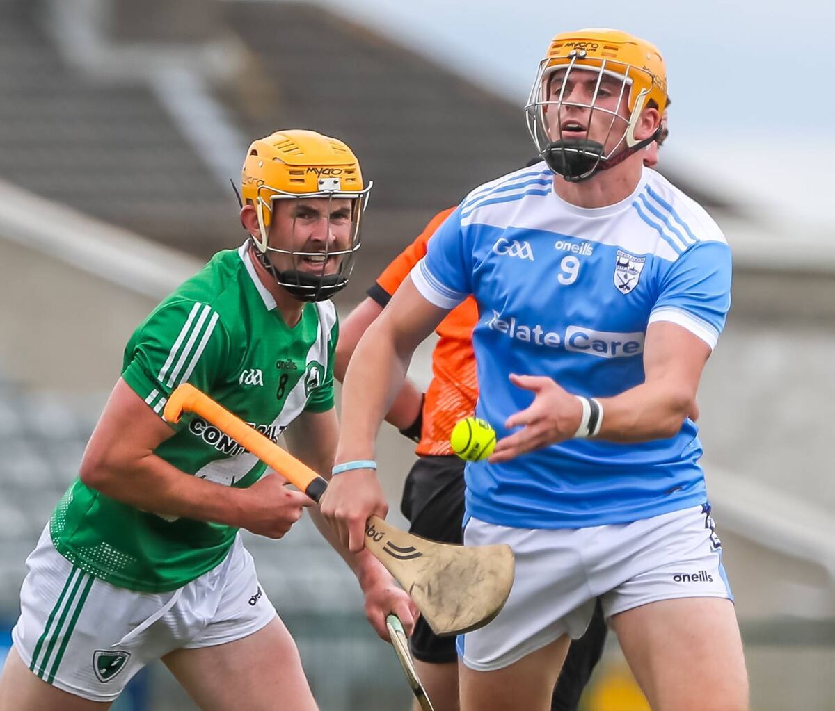 Roanmore's Rory Furlong hand passes the sliotar ahead of Clonea's Robbie Flynn. Picture: Maurice Hennebry