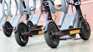 Electric scooters parked on a city street. Self-service transport rental system, e-scooters during a rain