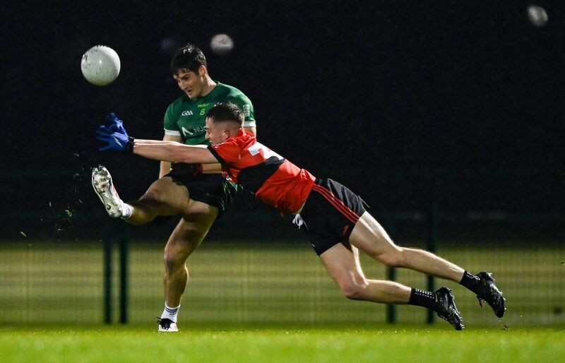 Liam Evans of UCC attempts to block the kick of Dan Higgins of Queen's University Belfast. Picture: Tyler Miller/Sportsfile