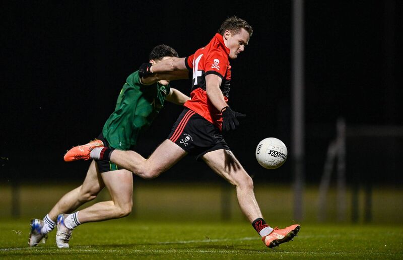 Conor Daly of UCC shoots on goal despite the efforts of Joey Clarke of Queen's University Belfast. Picture: Tyler Miller/Sportsfile