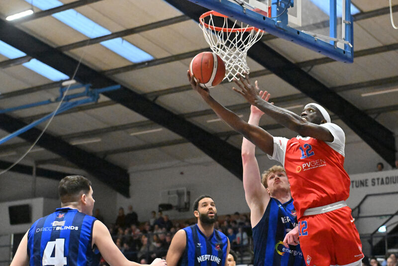  Tamyrik Fields, UCC Demons, rises high to score watched by Eoin Nelson of Neptune. Picture: Dan Linehan