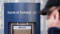 A man walks past a Bank of Ireland branc