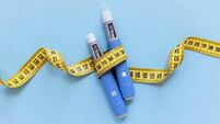 Two injectors dosing pens for subcutaneous injection of antidiabetic medication or anti-obesity medication hovering over a blue