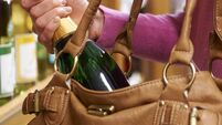Woman Stealing Bottle Of Wine From Supermarket