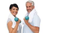 Fit mature couple exercising with dumbbells