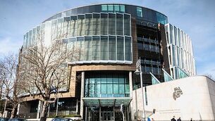 person walking in front of The Criminal Courts of Justice in Dublin, Ireland