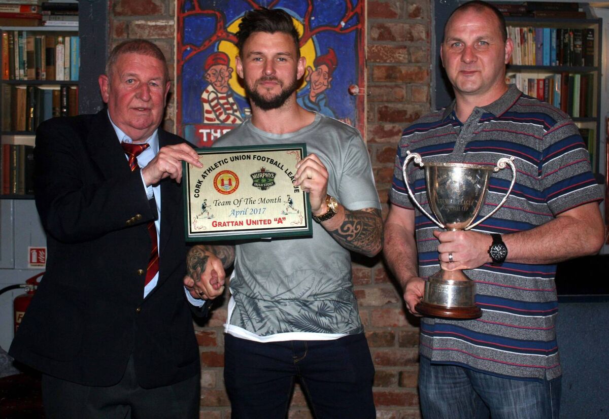 Tony Chambers (Cork AUL) presents the team of the month award to Grattan United's captain Eric Shinkwin. Also in picture is Darren Geaney displaying the Premiership trophy. Pic; Barry Peelo.