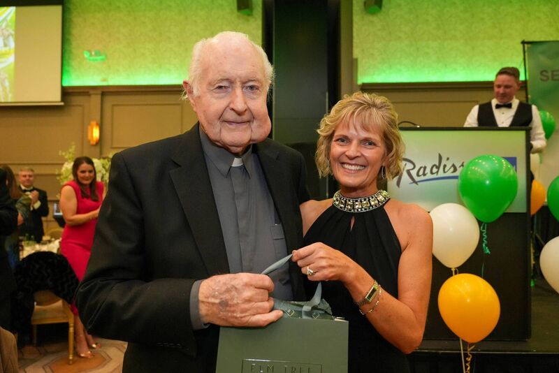 Archdeadon O'Donnell receiving a token of congratulations from Bride Rovers club secretary Rosario Kielty at the club's celebration dinner.