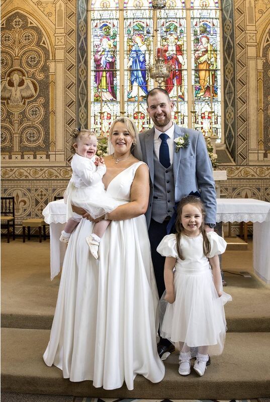 The couple pictured with their daughters on their wedding day. 