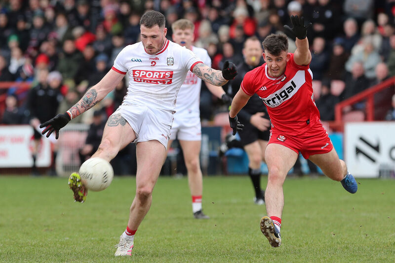 Cork’s Seán Walsh scores a point as Derry's Shea Downey attempts a block. Picture: INPHO/Lorcan Doherty