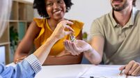 Happy couple receiving new house keys from real estate agent
