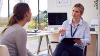 Woman Doctor Or GP In Office Meeting Teenage Female Patient For Appointment