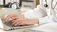 Close up of doctor woman hands typing on laptop siting on a desk at the office