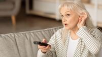 Hearing Problems. Mature woman watching television sitting on couch